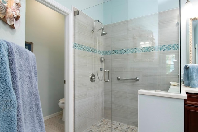 bathroom with toilet, tile floors, an enclosed shower, and vanity