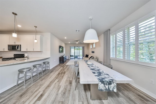 interior space featuring ceiling fan, sink, and light hardwood / wood-style flooring