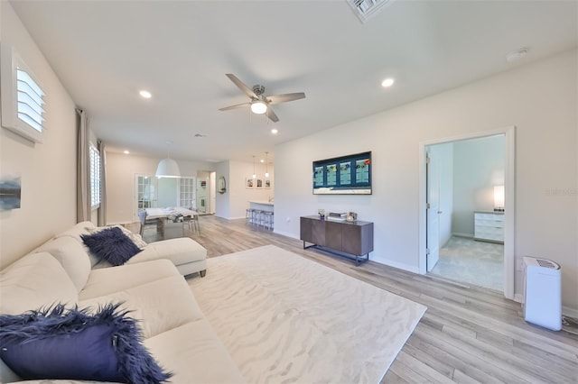 living room with ceiling fan and light wood-type flooring