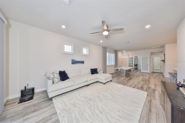 living room featuring ceiling fan, light wood-type flooring, and french doors