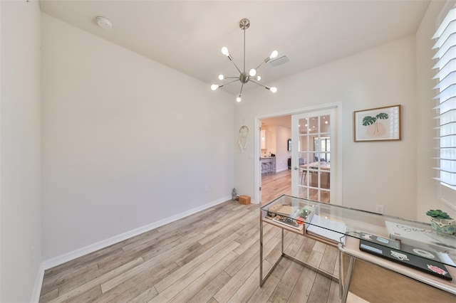 office space with light hardwood / wood-style flooring, a notable chandelier, and a healthy amount of sunlight