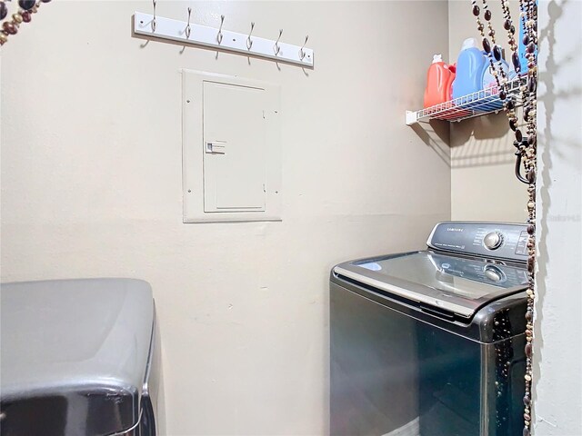 clothes washing area with electric panel and separate washer and dryer