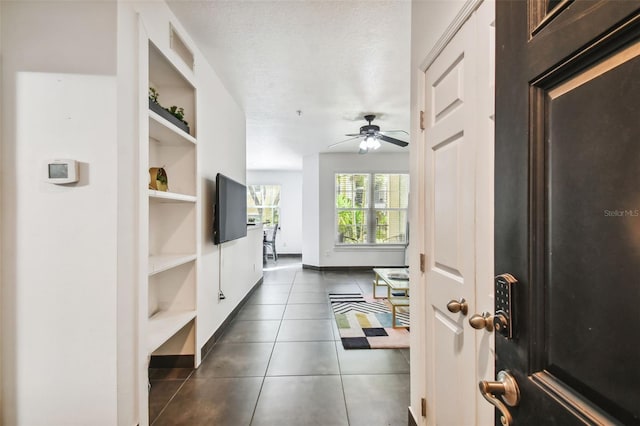 interior space featuring a textured ceiling, ceiling fan, and built in shelves