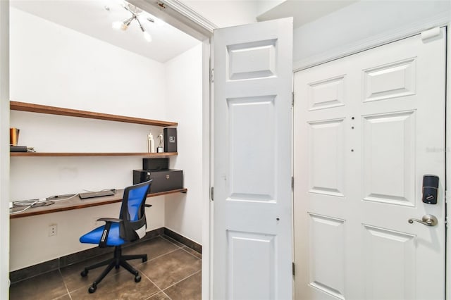 office area featuring built in desk, dark tile floors, and a notable chandelier