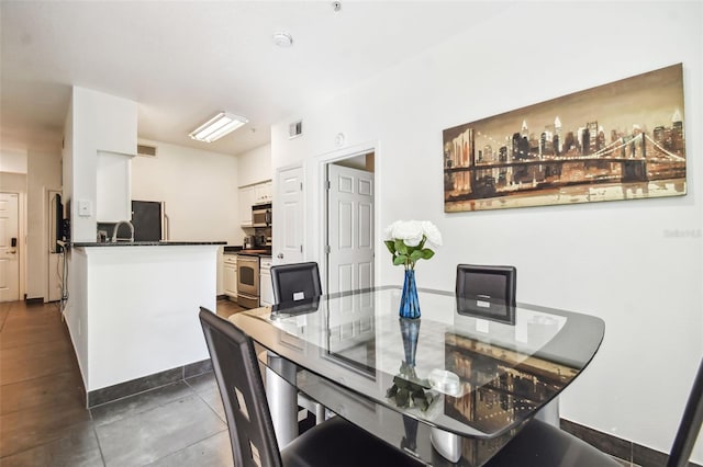 dining area with sink and dark tile flooring