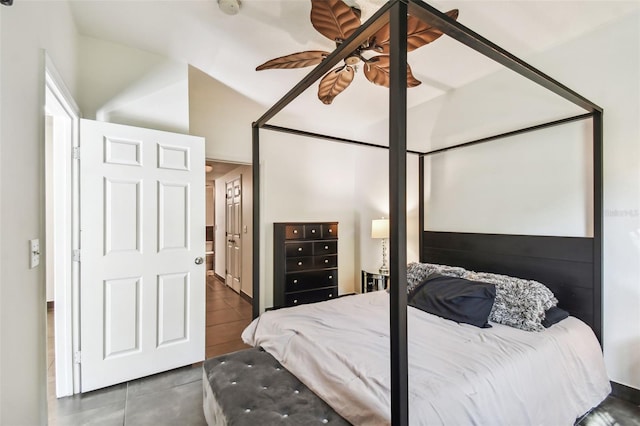 bedroom featuring dark tile flooring, ceiling fan, and vaulted ceiling