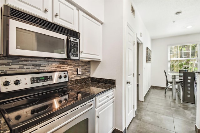 kitchen featuring light tile flooring, tasteful backsplash, stainless steel appliances, and white cabinetry