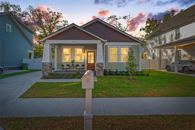 view of front facade featuring covered porch and a yard