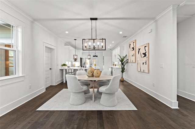 dining area featuring dark hardwood / wood-style floors, ornamental molding, and a notable chandelier