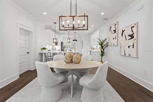 dining area with a notable chandelier, dark hardwood / wood-style flooring, and crown molding