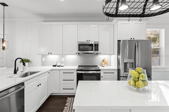 kitchen featuring white cabinets, stainless steel appliances, hanging light fixtures, and sink