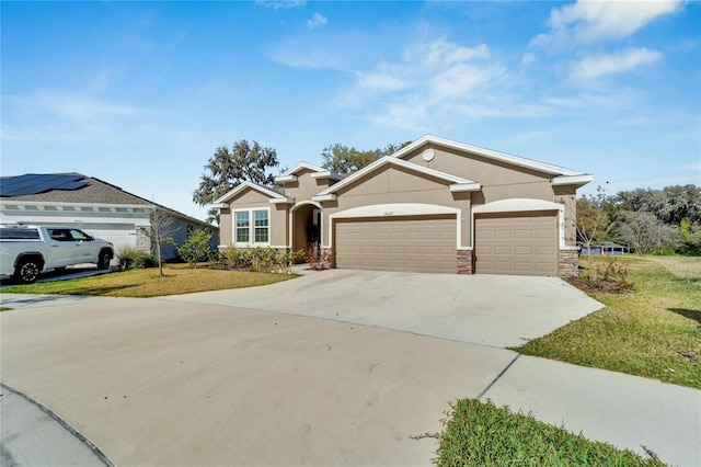 ranch-style home with solar panels, a front yard, and a garage