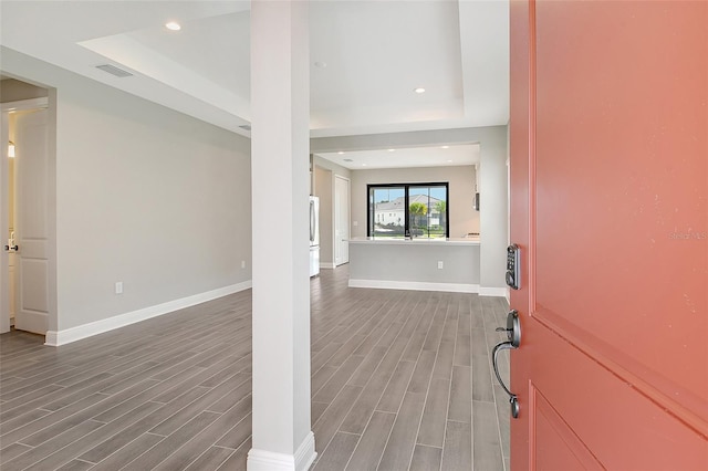 foyer entrance with a tray ceiling and hardwood / wood-style floors