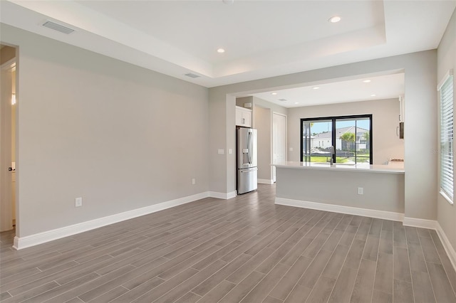 interior space featuring a raised ceiling, sink, and hardwood / wood-style floors