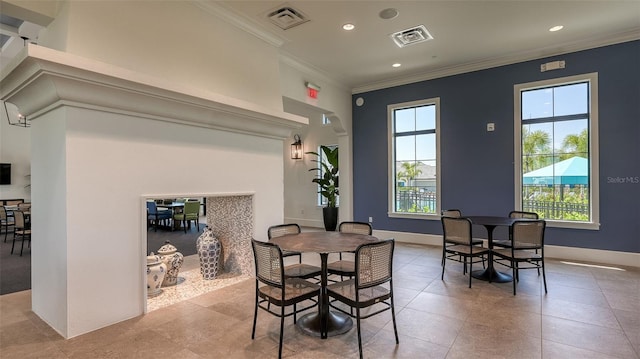 dining room with light tile patterned flooring and crown molding