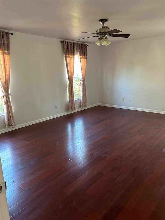 unfurnished room with ceiling fan and dark wood-type flooring