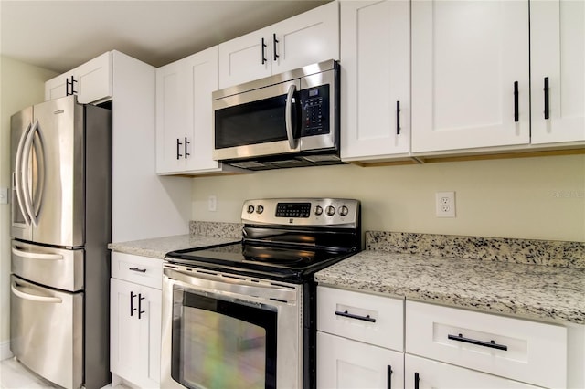 kitchen featuring light stone countertops, white cabinets, and stainless steel appliances