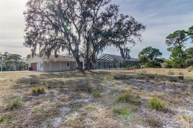 view of yard featuring a lanai and a garage