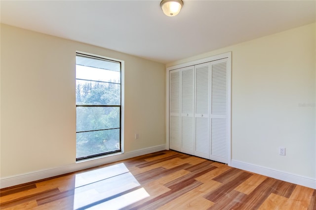 unfurnished bedroom featuring light wood-type flooring and a closet