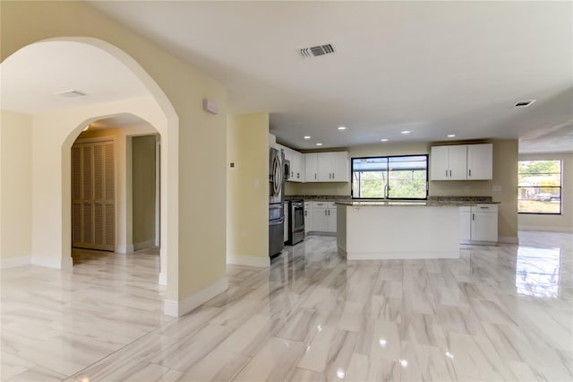 kitchen with a center island, stainless steel appliances, white cabinetry, and sink