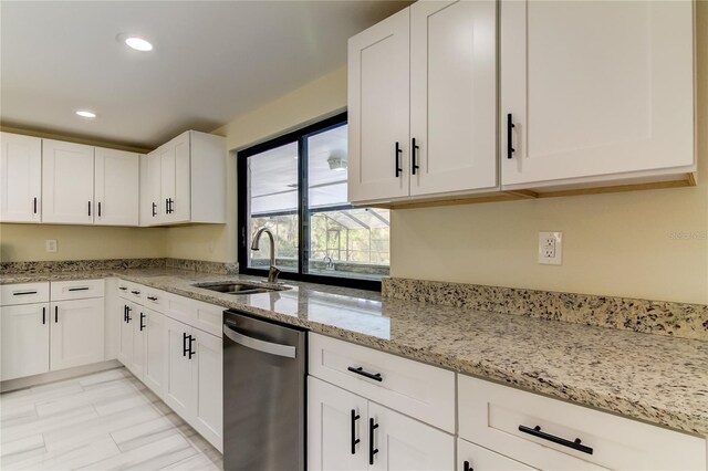 kitchen with white cabinets, dishwasher, light stone counters, and sink