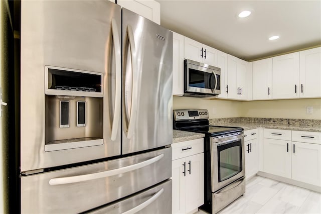 kitchen featuring white cabinets, stainless steel appliances, and light stone counters