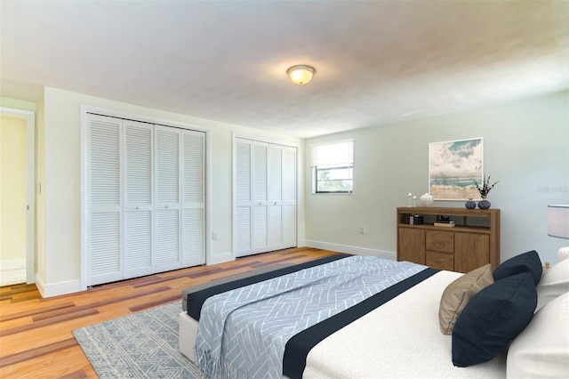 bedroom featuring hardwood / wood-style floors and multiple closets