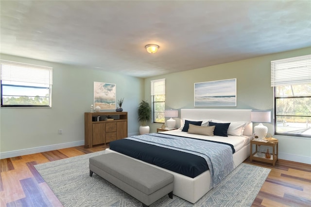 bedroom featuring multiple windows and light hardwood / wood-style flooring