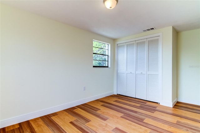 unfurnished bedroom with a closet and light wood-type flooring