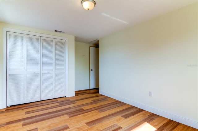 unfurnished bedroom featuring light hardwood / wood-style flooring and a closet