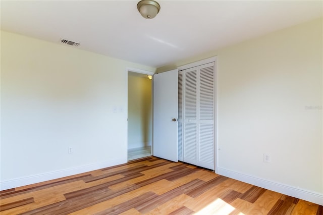 unfurnished bedroom featuring light hardwood / wood-style flooring and a closet