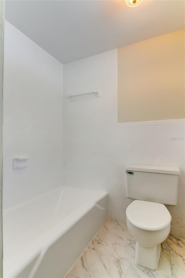 bathroom featuring a tub and toilet