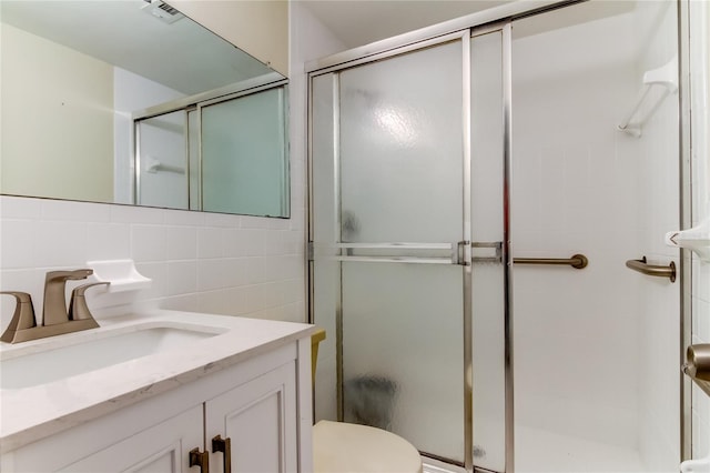 bathroom with walk in shower, tasteful backsplash, toilet, vanity, and tile walls