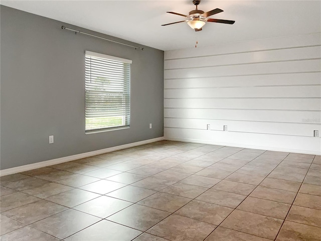 tiled spare room with ceiling fan