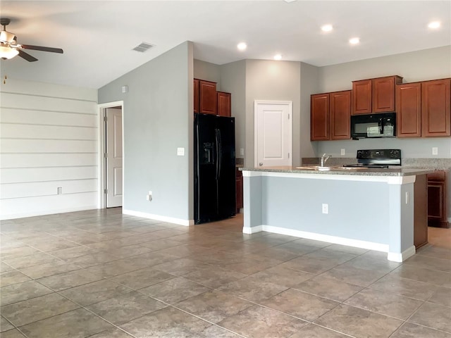 kitchen with light stone countertops, a kitchen island with sink, ceiling fan, and black appliances