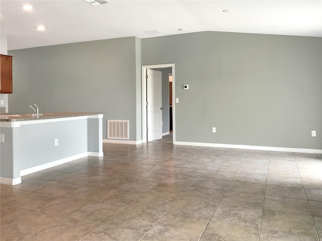 unfurnished living room featuring lofted ceiling and sink