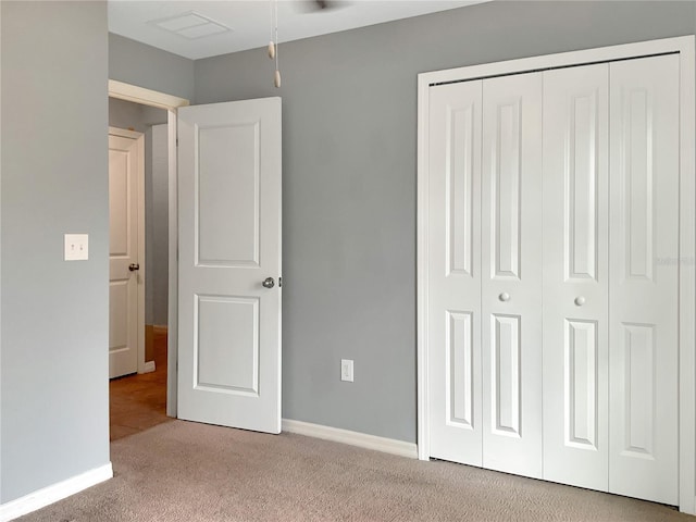 unfurnished bedroom with light colored carpet and a closet