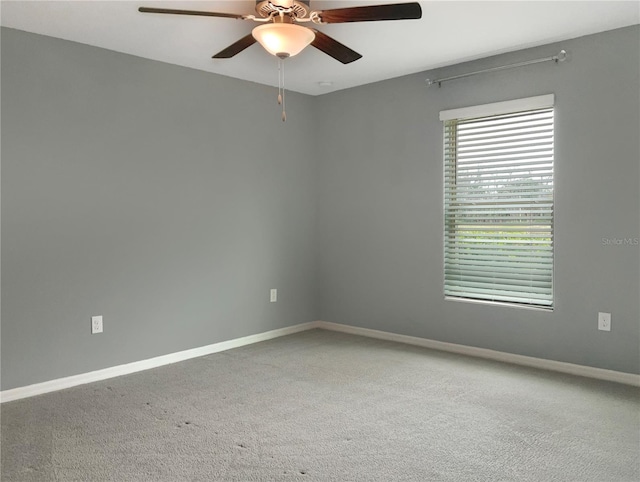 carpeted spare room featuring ceiling fan