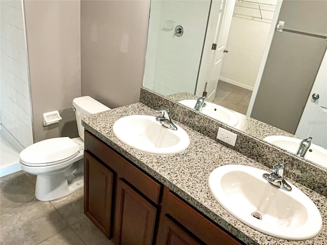 bathroom with vanity, toilet, and a tile shower