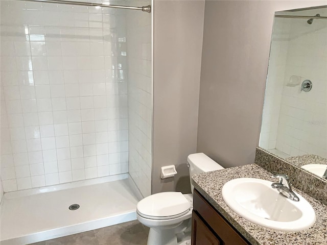 bathroom featuring vanity, tiled shower, and toilet