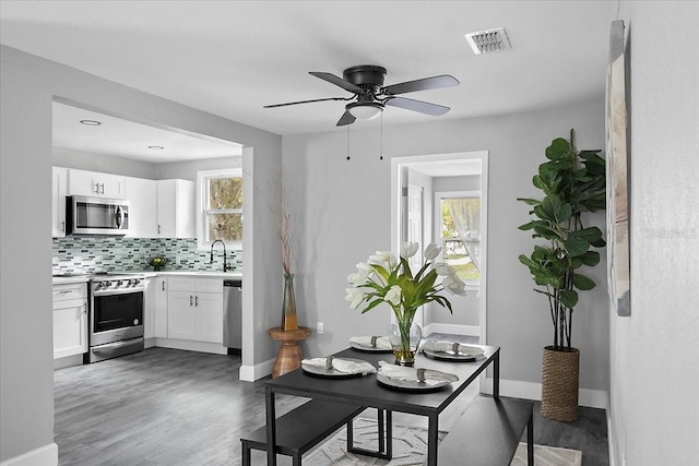 dining area featuring dark hardwood / wood-style floors, ceiling fan, and sink