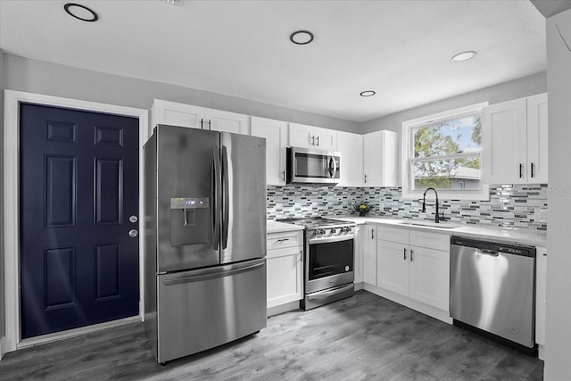 kitchen with white cabinetry, appliances with stainless steel finishes, dark wood-type flooring, and sink