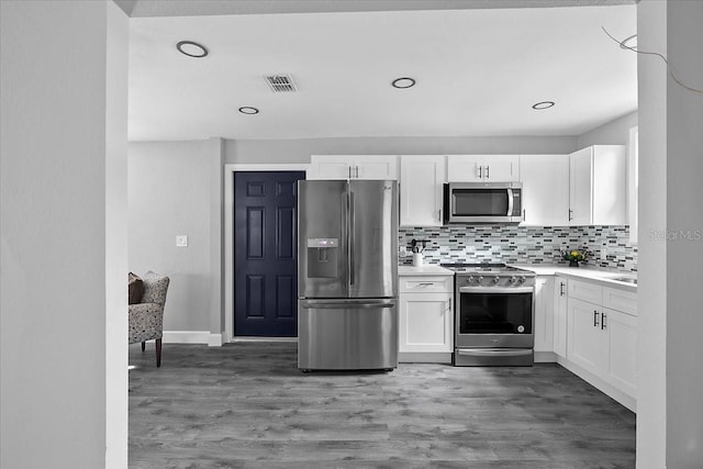 kitchen with white cabinetry, dark hardwood / wood-style floors, tasteful backsplash, and stainless steel appliances