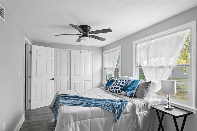 bedroom with dark hardwood / wood-style flooring, a closet, and ceiling fan