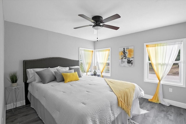 bedroom with dark hardwood / wood-style flooring and ceiling fan