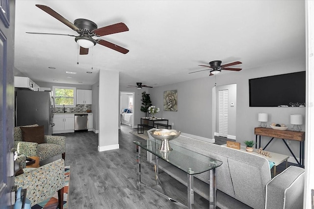 living room featuring ceiling fan, dark hardwood / wood-style floors, and sink