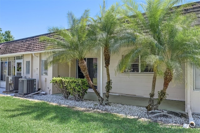 property entrance with a yard and central AC