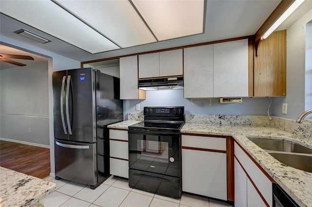 kitchen featuring white cabinetry, sink, light tile patterned floors, and black appliances