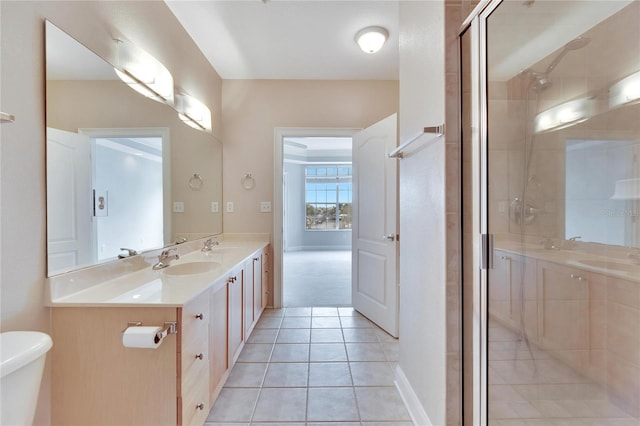 bathroom with tile patterned flooring, vanity, toilet, and a shower with door