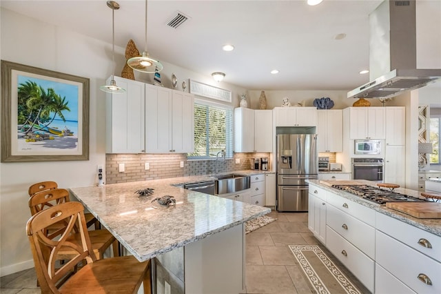 kitchen featuring a center island, white cabinets, appliances with stainless steel finishes, island range hood, and a kitchen bar